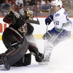 Arizona Coyotes' Mike Smith, left, makes a save on a shot by Vancouver Canucks' Bo Horvat (53) during the first period of an NHL hockey game Thursday, March 5, 2015, in Glendale, Ariz. (AP Photo/Ross D. Franklin)