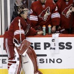 Arizona Coyotes goalie Mike Smith, left, pauses near backup goalie Louis Domingue, middle, and Michael Stone during an NHL hockey game against the New Jersey Devils, Saturday, March 14, 2015, in Glendale, Ariz. The Devils defeated the Coyotes 4-1 after Smith gave up three goals in the third period. (AP Photo/Ross D. Franklin)