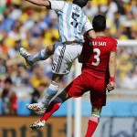 Argentina's Fernando Gago, left, challenges Iran's Ehsan Haji Safi during the group F World Cup soccer match between Argentina and Iran at the Mineirao Stadium in Belo Horizonte, Brazil, Saturday, June 21, 2014. (AP Photo/Victor R. Caivano)
