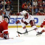 Detroit Red Wings goalie Jimmy Howard (35) stops a shot by Arizona Coyotes center Tobias Rieder as Henrik Zetterberg (40) defends during the third period of an NHL hockey game in Detroit on Tuesday, March 24, 2015. Arizona won 5-4 in overtime. (AP Photo/Paul Sancya)