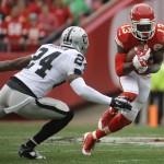 Kansas City Chiefs running back De'Anthony Thomas (13) carries a punt return against Oakland Raiders free safety Charles Woodson (24) during the first half of an NFL football game in Kansas City, Mo., Sunday, Dec. 14, 2014. (AP Photo/Charlie Riedel)