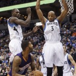 Phoenix Suns' Markieff Morris, center, eyes the basket as Minnesota Timberwolves' Gorgui Dieng, left, and Adreian Payne hover over him during the first quarter of an NBA basketball game, Friday, Feb. 20, 2015, in Minneapolis. (AP Photo/Jim Mone)