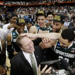 Michigan State head coach Tom Izzo, center front, celebrates with his team after the regional final against Louisville in the NCAA men's college basketball tournament Sunday, March 29, 2015, in Syracuse, N.Y. Michigan State won the game 76-70. (AP Photo/Seth Wenig)