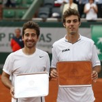 Spanish pair Marcel Granollers, right, and Marc Lopez pose with their trophies after losing their men's doubles final match against French pair Julien Benneteau and Edouard Roger-Vasselin in the French Open tennis tournament at the Roland Garros stadium, in Paris, France, Saturday, June 7, 2014. (AP Photo/Darko Vojinovic)