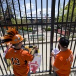 Fans Romeo Santos, left, and Matt Fouse gather ahead of a Baltimore Orioles baseball game against the Chicago White Sox's, Wednesday, April 29, 2015, outside Oriole Park at CamdenYards in Baltimore. The game was played in an empty Oriole Park at Camden Yards amid unrest in Baltimore over the death of Freddie Gray at the hands of police. (AP Photo/Matt Rourke)