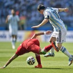 Argentina's Lionel Messi tries to get the ball away from Iran's Mehrdad Pooladi during the group F World Cup soccer match between Argentina and Iran at the Mineirao Stadium in Belo Horizonte, Brazil, Saturday, June 21, 2014. (AP Photo/Martin Meissner)