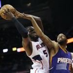 Atlanta Hawks' DeMarre Carroll, left, puts up a shot against Phoenix Suns' Marcus Morris in the first quarter of an NBA basketball game Tuesday, April 7, 2015, in Atlanta. The Hawks set a single-season franchise high with their 58th victory, getting 16 points each from Carroll and Jeff Teague in a 96-69 win. (AP Photo/David Goldman)