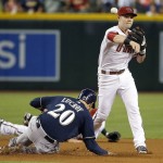 Arizona Diamondbacks' Chris Owings, right, throws to first base after forcing out Milwaukee Brewers' Jonathan Lucroy (20) during the first inning of a baseball game Friday, July 24, 2015, in Phoenix. Brewers' Ryan Braun reached first base safely on the fielder's choice. (AP Photo/Ross D. Franklin)
