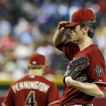 Arizona Diamondbacks' Brandon McCarthy, right, adjusts his cap after talking with teammates, including Cliff Pennington (4), on the mound during the sixth inning of a baseball game against the New York Mets, Wednesday, April 16, 2014, in Phoenix. (AP Photo/Ross D. Franklin)
