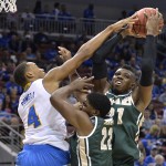 UCLA's Norman Powell, left, attempts to block the shot of UAB's Tosin Mehinti during the second half of an NCAA tournament third round college basketball game in Louisville, Ky., Saturday, March 21, 2015. In the middle is UAB's Tyler Madison. (AP Photo/Timothy D. Easley)