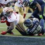 San Francisco 49ers running back Frank Gore dives in ahead of Seattle Seahawks free safety Earl Thomas to score a touchdown in the first half of an NFL football game, Sunday, Dec. 14, 2014, in Seattle. (AP Photo/Elaine Thompson)