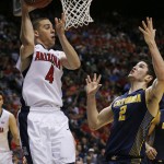 Arizona's T.J. McConnell (4) passes around California's Sam Singer in the second half of an NCAA college basketball game in the quarterfinals of the Pac-12 conference tournament Thursday, March 12, 2015, in Las Vegas. (AP Photo/John Locher)