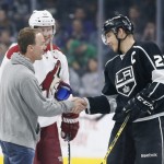 NASCAR driver Kevin Harvick, left, shakes hands with Los Angeles Kings right wing Dustin Brown, right, and Arizona Coyotes right wing Shane Doan, center, after dropping the ceremonial first puck before the first period of an NHL hockey game, Monday, March 16, 2015, in Los Angeles. (AP Photo/Danny Moloshok)