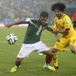  Cameroon's Benoit Assou-Ekotto (2) tries to pull Mexico's Giovani dos Santos (10) away from the ball during the second half of the group A World Cup soccer match between Mexico and Cameroon in the Arena das Dunas in Natal, Brazil, Friday, June 13, 2014. (AP Photo/Petr David Josek)