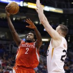 Houston Rockets' Patrick Beverley (2) drives to the basket as Phoenix Suns' Miles Plumlee, right, defends during the first half of an NBA basketball game Tuesday, Feb. 10, 2015, in Phoenix. (AP Photo/Ross D. Franklin)
