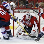 New York Rangers right wing Martin St. Louis (26) reaches over Washington Capitals right wing Joel Ward (42) as goalie Braden Holtby (70) blocks the shot during the second period of Game 3 in the second round of the NHL Stanley Cup hockey playoffs, Monday, May 4, 2015, in Washington. (AP Photo/Alex Brandon)