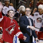 New Arizona Coyotes majority owner Andrew Barroway, right, walks onto the ice with son Jake Barroway, left, as they wave to fans before the ceremonial first puck drop prior to an NHL hockey game against the Columbus Blue Jackets Saturday, Jan. 3, 2015, in Glendale, Ariz. (AP Photo/Ross D. Franklin)