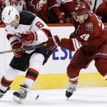 New Jersey Devils' Dainius Zubrus (8), of Russia, and Arizona Coyotes' Lauri Korpikoski (28), of Finland, battle for the puck during the first period of an NHL hockey game Saturday, March 14, 2015, in Glendale, Ariz. (AP Photo/Ross D. Franklin)