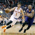 New York Knicks' Alexey Shved (1), of Russia, drives to the basket past Phoenix Suns' P.J. Tucker during the first half of an NBA basketball game, Sunday, March 15, 2015 in Phoenix. (AP Photo/Ralph Freso)