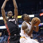 Phoenix Suns' Eric Bledsoe, right, tries to get off a shot as he gets past Miami Heat's Chris Bosh (1) during the second half of an NBA basketball game Tuesday, Dec. 9, 2014, in Phoenix. The Heat won 103-97. (AP Photo/Ross D. Franklin)