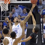 Kentucky's Willie Cauley-Stein, left, blocks the shot of Cincinnati's Troy Caupain during the second half of an NCAA tournament college basketball game in Louisville, Ky., Saturday, March 21, 2015. (AP Photo/Timothy D. Easley)