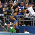 A fan reaches for the ball on a three-run home run by Los Angeles Dodgers' Yasiel Puig during the second inning of a baseball game against the Arizona Diamondbacks, Wednesday, June 10, 2015, in Los Angeles. (AP Photo/Mark J. Terrill)