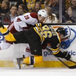 Phoenix Coyotes left wing Lauri Korpikoski (28) knocks down Boston Bruins defenseman Kevan Miller during the first period of an NHL hockey game in Boston Thursday, March 13, 2014. (AP Photo/Winslow Townson)
