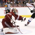 Arizona Coyotes' Mike Smith, left, makes a glove save on a shot as Colorado Avalanche's Marc-Andre Cliche (24) moves in for a possible play during the first period of an NHL hockey game Tuesday, Nov. 25, 2014, in Glendale, Ariz. (AP Photo/Ross D. Franklin)