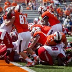 Illinois running back Donovonn Young (5), right, leaps over the pile for a touchdown during NCAA college football game against Western Kentucky, Saturday, Sept. 6, 2014, in Champaign, Ill. (AP Photo/The Daily News, Austin Anthony)