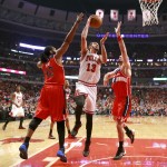Chicago Bulls center Joakim Noah (13) shoots between Washington Wizards forward Nene Hilario (42) and Marcin Gortat during the first half of Game 2 in an opening-round NBA basketball playoff series Tuesday, April 22, 2014, in Chicago. (AP Photo/Charles Rex Arbogast)