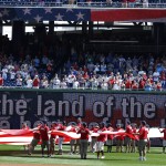 A flag is unfurled in the outfield during the singing of the Star Spangled Banner before a baseball game between the Washington Nationals and the Chicago Cubs at Nationals Park, Friday, July 4, 2014, in Washington. This year is the 200th anniversary of Francis Scott Key's famous song. (AP Photo/Alex Brandon)