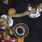 Los Angeles Clippers' DeAndre Jordan, bottom left, goes up for a rebound along with San Antonio Spurs' Boris Diaw, left, and Kawhi Leonard during the first half of Game 3 in an NBA basketball first-round playoff series, Friday, April 24, 2015, in San Antonio. (AP Photo/Darren Abate)