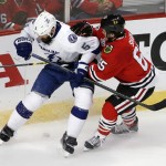 Chicago Blackhawks' Andrew Shaw, right, prepares to check Tampa Bay Lightning's Jason Garrison into the boards during the first period in Game 6 of the NHL hockey Stanley Cup Final series on Monday, June 15, 2015, in Chicago. (AP Photo/Charles Rex Arbogast)