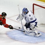 Tampa Bay Lightning goalie Ben Bishop, right, stops a shot from Chicago Blackhawks' Antoine Vermette during the second period in Game 3 of the NHL hockey Stanley Cup Final on Monday, June 8, 2015, in Chicago. (AP Photo/Charles Rex Arbogast)