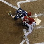 Arizona Diamondbacks' Bronson Arroyo scores past Milwaukee Brewers catcher Jonathan Lucroy during the eighth inning of a baseball game Wednesday, May 7, 2014, in Milwaukee. Arroyo scored from third on a ball hit by Gerardo Parra and a Brewers' error. (AP Photo/Morry Gash)