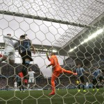 England's Wayne Rooney, left, in white, heads the ball at the crossbar as Uruguay's goalkeeper Fernando Muslera, right in orange, watches during the group D World Cup soccer match between Uruguay and England at the Itaquerao Stadium in Sao Paulo, Brazil, Thursday, June 19, 2014. (AP Photo/Thanassis Stavrakis)