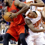 Phoenix Suns' Isaiah Thomas (3) fouls Toronto Raptors' Amir Johnson during the first half of an NBA basketball game, Sunday, Jan. 4, 2015, in Phoenix. (AP Photo/Matt York)