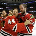 Chicago Blackhawks' Kimmo Timonen (44), of Finland, and Niklas Hjalmarsson (4), of Sweden, celebrate after defeating the Tampa Bay Lightning in Game 6 of the NHL hockey Stanley Cup Final series on Monday, June 15, 2015, in Chicago. The Blackhawks defeated the Lightning 2-0 to win the series 4-2. (AP Photo/Nam Y. Huh)
