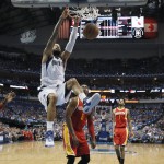 Dallas Mavericks' Tyson Chandler, top, scores against the Houston Rockets during the first half of Game 3 in an NBA basketball first-round playoff series Friday, April 24, 2015, in Dallas. (AP Photo/Tony Gutierrez)