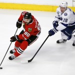 Chicago Blackhawks' Antoine Vermette, left, handles the puck as Tampa Bay Lightning's Ondrej Palat, of the Czech Republic, gives chase during the first period in Game 6 of the NHL hockey Stanley Cup Final series on Monday, June 15, 2015, in Chicago. (AP Photo/Charles Rex Arbogast)