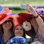 Fans shoot a selfie before the 141st running of the Kentucky Oaks horse race at Churchill Downs Friday, May 1, 2015, in Louisville, Ky. (AP Photo/Darron Cummings)