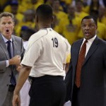 Golden State Warriors head coach Steve Kerr, left, and assistant coach Alvin Gentry, right, talk with referee James Capers (19) during the first half of Game 5 of basketball's NBA Finals against the Cleveland Cavaliers in Oakland, Calif., Sunday, June 14, 2015. (AP Photo/Ben Margot)
