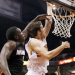 Phoenix Suns' Goran Dragic, right, of Slovenia, gets past Miami Heat's Luol Deng (9) to score during the second half of an NBA basketball game Tuesday, Dec. 9, 2014, in Phoenix. The Heat defeated the Suns 103-97. (AP Photo/Ross D. Franklin)
