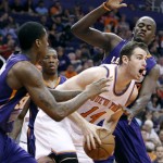 New York Knicks' Jason Smtih (14) looks to pass between Phoenix Suns' Archie Goodwin, left, and Earl Barron during the second half of an NBA basketball game Sunday, March 15, 2015, in Phoenix. The Suns defeated the Knicks 102-89. (AP Photo/Ralph Freso)