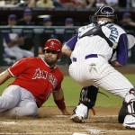 Los Angeles Angels' Albert Pujols, left, scores a run ahead of the tag by Arizona Diamondbacks' Jarrod Saltalamacchia, right, during the sixth inning of a baseball game Thursday, June 18, 2015, in Phoenix. (AP Photo/Ross D. Franklin)
