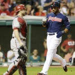 Cleveland Indians' Chris Dickerson, right, scores on an RBI-double by Indians' Jason Kipnis in the third inning of a baseball game, Tuesday, Aug. 12, 2014, in Cleveland. Diamondbacks catcher Miguel Montero watches. (AP Photo/Tony Dejak)