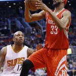 Houston Rockets' Corey Brewer (33) drives to the basket as Phoenix Suns' P.J. Tucker (17) looks on during the first half of an NBA basketball game Tuesday, Feb. 10, 2015, in Phoenix. (AP Photo/Ross D. Franklin)