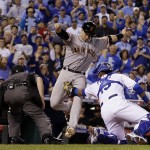 San Francisco Giants' Buster Posey is tagged out by Kansas City Royals catcher Salvador Perez during the first inning of Game 1 of baseball's World Series Tuesday, Oct. 21, 2014, in Kansas City, Mo. Posey tried to score from second on a hit by Pablo Sandoval. (AP Photo/David J. Phillip)