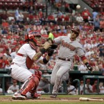 Arizona Diamondbacks' Martin Prado, right, scores on a sacrifice fly by Aaron Hill as the throw bounces away from St. Louis Cardinals catcher Yadier Molina during the first inning of a baseball game Thursday, May 22, 2014, in St. Louis. (AP Photo/Jeff Roberson)

