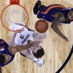 New Orleans Pelicans center Omer Asik (3) goes to the basket between Phoenix Suns forward Brandan Wright, left, and forward Marcus Morris, right, in the first half of an NBA basketball game in New Orleans, Friday, April 10, 2015. (AP Photo/Gerald Herbert)
